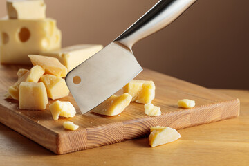 Parmesan cheese and knife on a cutting board.