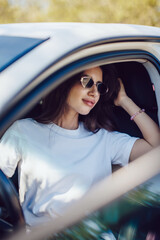 Stylish Woman Sitting in Car Wearing Sunglasses