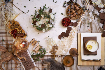 Flat lay of a completed handmade dried flower wreath placed on a bright wooden table, surrounded by...