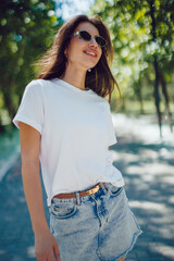 Happy Young Woman In White T-Shirt And Denim Skirt Walking In Park