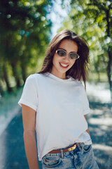 Happy Young Woman In White T-Shirt And Denim Skirt Walking In Park