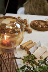 Flat lay composition showing natural materials for making a dried flower wreath. Includes dried flowers, grasses, twine, scissors, floral wire, and a round base frame arranged on a rustic linen-covere