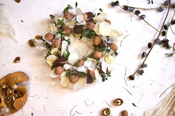 Flat lay of a completed handmade dried flower wreath placed on a bright wooden table, surrounded by...