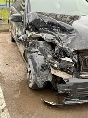 Car is severely damaged following a collision and road accident incident recently. This image features a detailed closeup of a car showing extensive frontend damage resulting from a serious accident