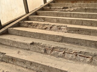 Weathered Concrete Steps Found in an Urban Environment and City Life Above and Below. An image showcasing worn concrete steps that reflect years of intense use and weathering in a public space