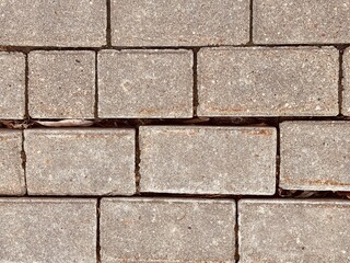A detailed description of a Gray Paving Stones Pattern used in various outdoor settings. Clos-eup of modern gray paving stones, highlighting their intricate texture and careful arrangement