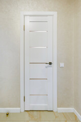 modern door handle on white wooden door in interior. Knob close-up elements. Door handle, fittings for interior design