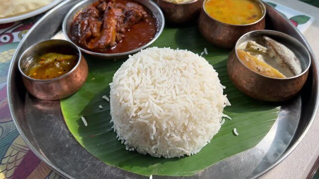 Bengali mutton thali served with lentils, rice, mutton in banana leaf