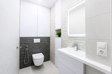 modern, minimalist bathroom with gray and white tones, featuring a floating toilet, sleek sink, and...