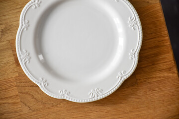 Top-Down View of Embossed White Dish on Wood