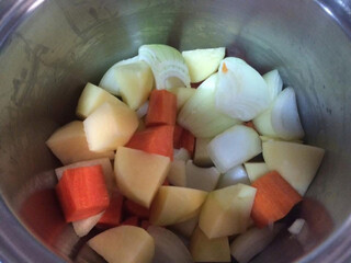 dice  Chopped carrots, onion, potato prepare for cooking in stainless steel pot