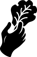 Silhouette of a hand holding a leafy vegetable