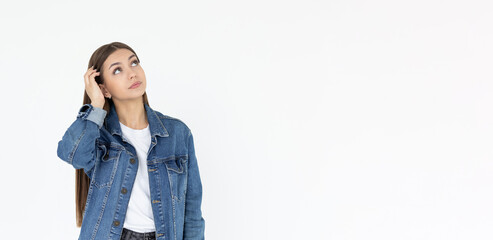 Young beautiful girl with long brown hair wearing jeans coat. freelancer looking away with confused disappointed expression, scratching head. student not remembers information for exam