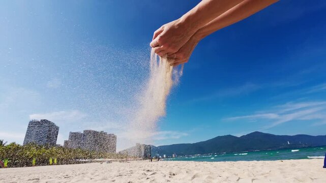 Beach sand scattered by women's hands