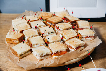 Party Platter of Mini Sandwich Bites. Assorted mini sandwiches arranged on a tray, each secured...
