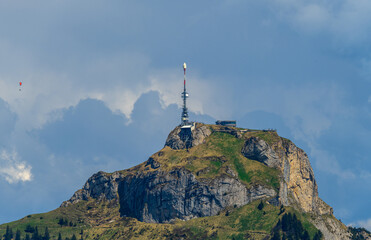 Tower stands tall on a rocky mountainside under a clear blue sky in a remote outdoor location...