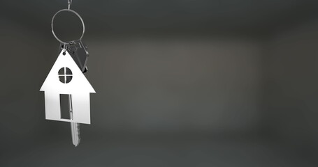 Obraz premium Hanging metallic house-shaped keychain and door key reflecting on dark grey backdrop, copy space