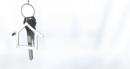 Hanging silver keyring swaying on white backdrop with metal keys and house-shaped charm, copy space