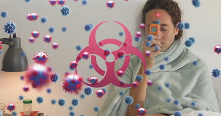 Measuring woman with infrared thermometer at home, pills, virus graphics and biohazard, copy space