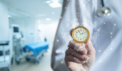 Doctor holds clock in hospital.