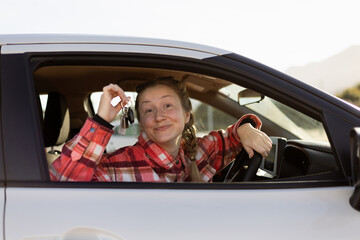 Woman Holding Car Keys Sitting Behind Steering Wheel