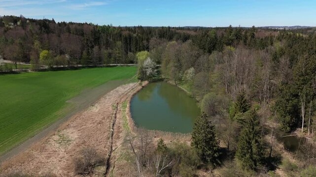 Stunning aerial view of Spiegelweiher serene lake chain near Grafing bei Muenchen, Bavaria, Deutschland. Crystal clear waters, lush spring greenery and trails create perfect scene for nature lovers. 
