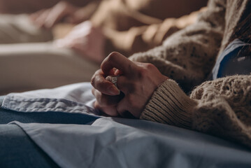 Upset woman twists ring on finger sitting on couch in therapy office