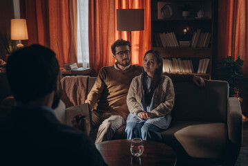 Obraz premium Delighted man and woman nod in agreement smiling during consultation with male psychologist
