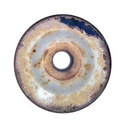 Rusted circular metal object on textured surface