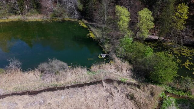 Stunning aerial view of Spiegelweiher serene lake chain near Grafing bei Muenchen, Bavaria, Deutschland. Crystal clear waters, lush spring greenery and trails create perfect scene for nature lovers. 