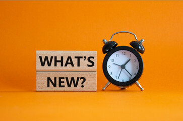 What is new symbol. Concept word What is new on wooden blocks. Beautiful orange background with...