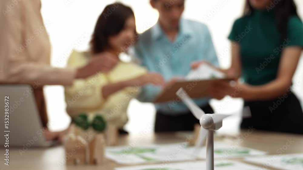 Poster windmill model represented using green energy and wooden block symbolized eco house was on table in 