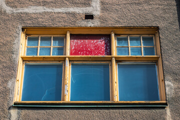 Old window with peeling paint and red patch.