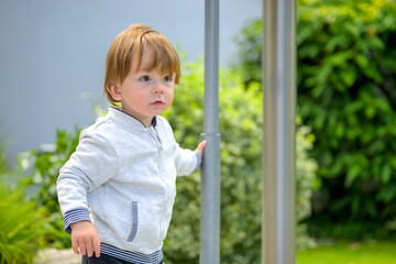 Curious Toddler Holding Pole
