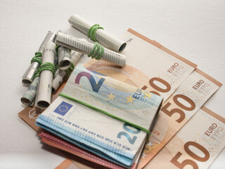 Closeup shot of a pile of Euro banknotes and rolled bills