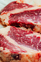 Obraz premium High-quality marbled beef steaks ready for grilling in a kitchen setting