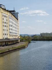 Vertical shot of the Weser River in the city of Hameln with beautiful buildings under a bright sky