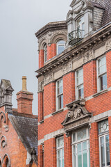 Vertical Victorian Gothic exterior, distinguished by its bold orange color and elaborate architectural ornaments.