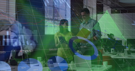 Collaborating, two colleagues analyzing financial data at office desk, with tablet folder charts