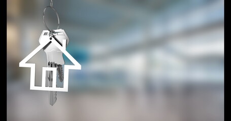 Suspending house-shaped metallic keychain holding metal keys in blurred modern lobby, copy space