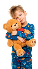 A smiling boy cuddles a teddy bear, radiating comfort and warmth in his pajamas.