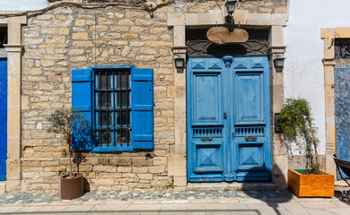 Blue door and window shutters adding charm to traditional stone house