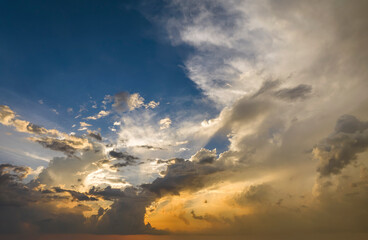 Dramatic sunset sky covered with colorful yellow clouds. Panoramic skyscape