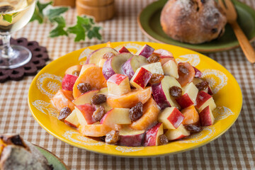 【りんごと柿のヨーグルトサラダ】林檎。柿。晩秋から冬に楽しめるサラダです。電子レンジでチンした薩摩芋とあわせてレーズンを散らして仕上げました。食材の味わいを引き立てるヨーグルトと蜂蜜のドレッシングで楽しみます。