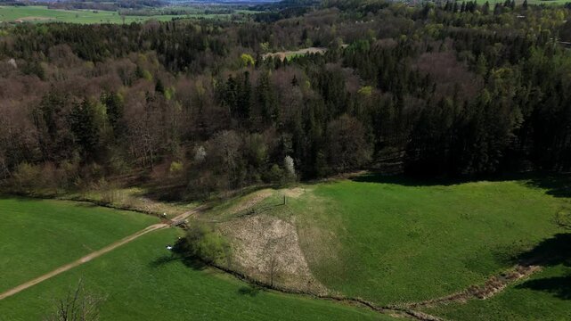 Idyllic grassy hill in Bavaria, Germany, crowned by the Mariensaeule monument. Surrounded by forests and fields, its ideal for spring hikes, sightseeing, and enjoying nature