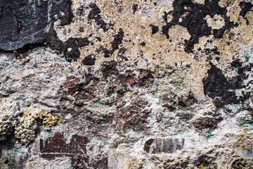 closeup of an old concrete wall with rough, weathered patches of dark and light colors. abstract grunge texture background with copy space