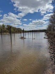 Fototapeta premium River poles stretching into the distance under partly cloudy skies – New Brunswick, NJ