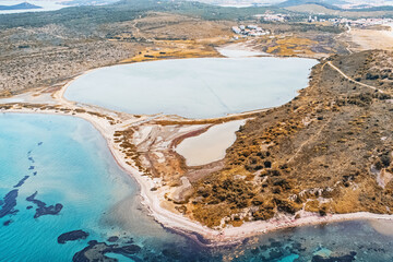 aerial view of a saltwater lake merging with the turquoise waters of the Aegean Sea, showcasing the...