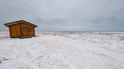 Wooden holiday cabin frozen land in winter. Iceland