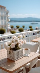 A charming wicker basket adorned with pink roses rests on a stylish balcony, offering a stunning view of the beach and mountains